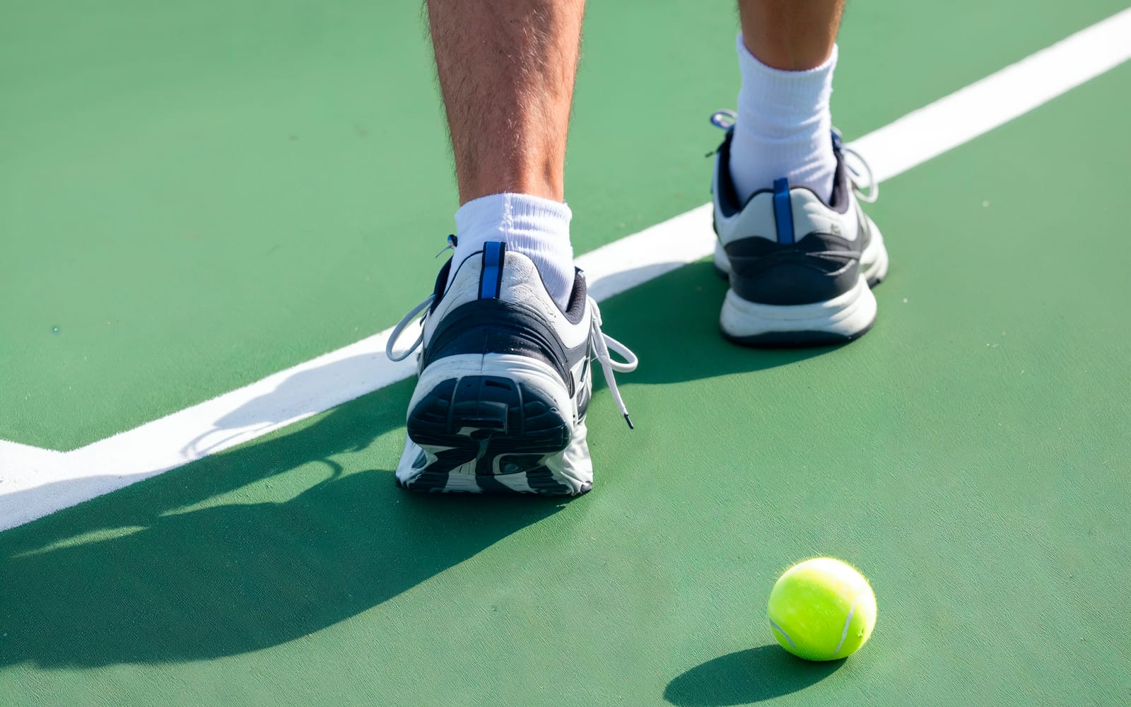 Photo de chaussures de padel posées sur le gazon synthétique d'un terrain