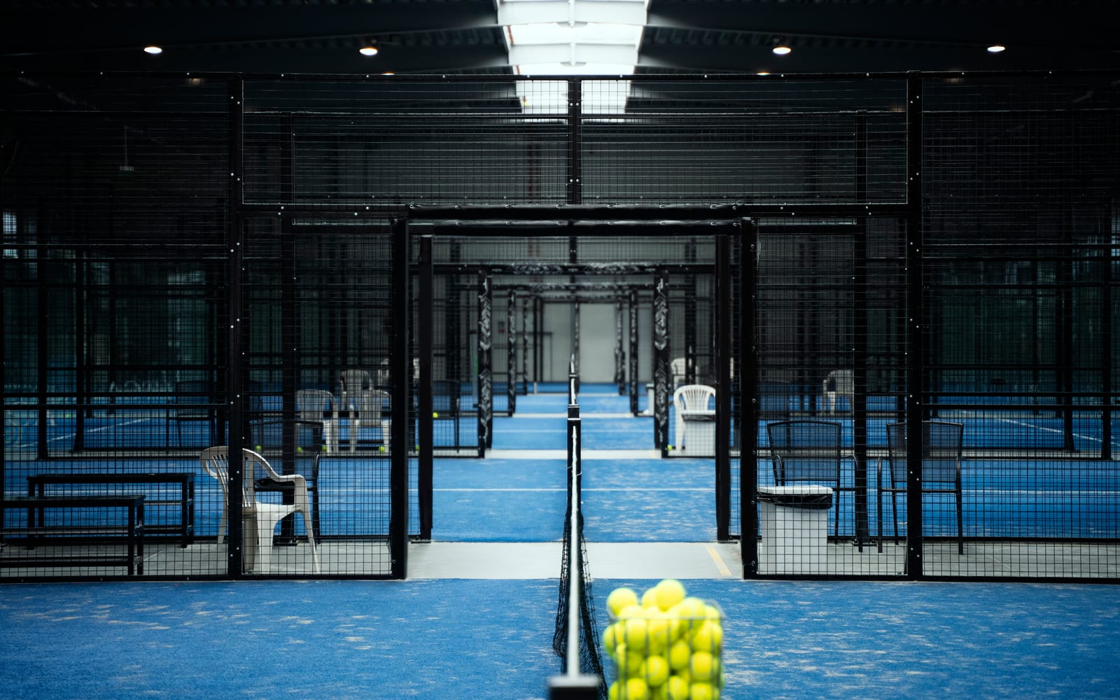 Vue extérieure de plusieurs courts de padel alignés dans un complexe sportif moderne